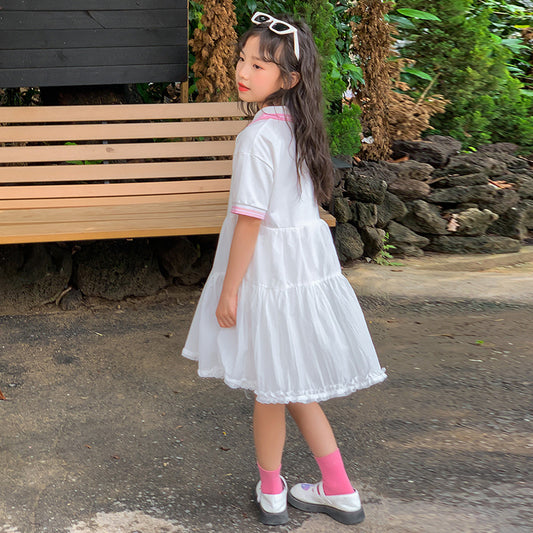 Child in a white dress with sunglasses on head
