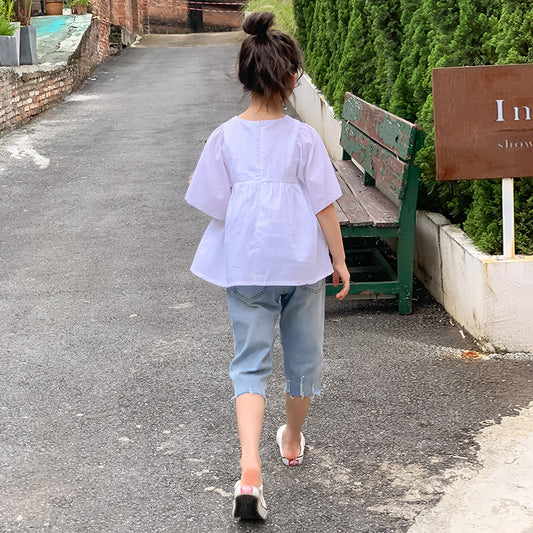 child in a purple blouse and denim pants