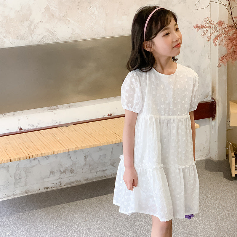 Child in a white dotted dress with a pink headband