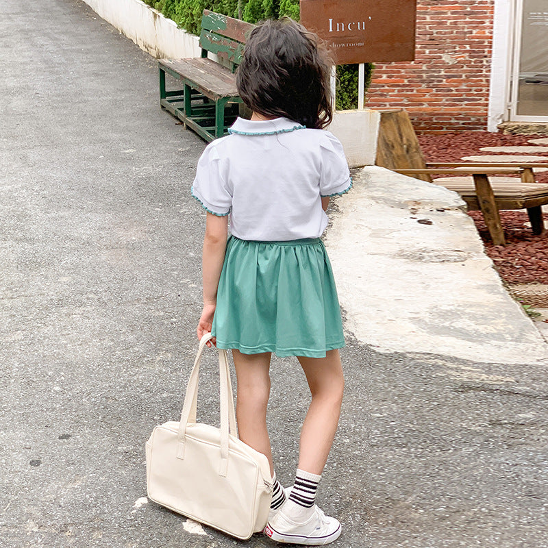 child with a green skirt and beige bag