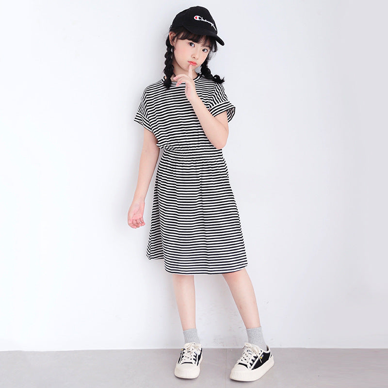 child in a black and white striped dress with a cap