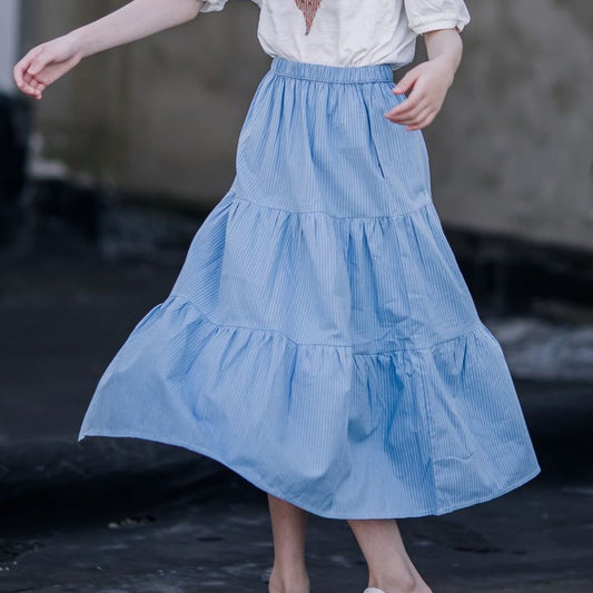 Child spinning in blue tiered skirt