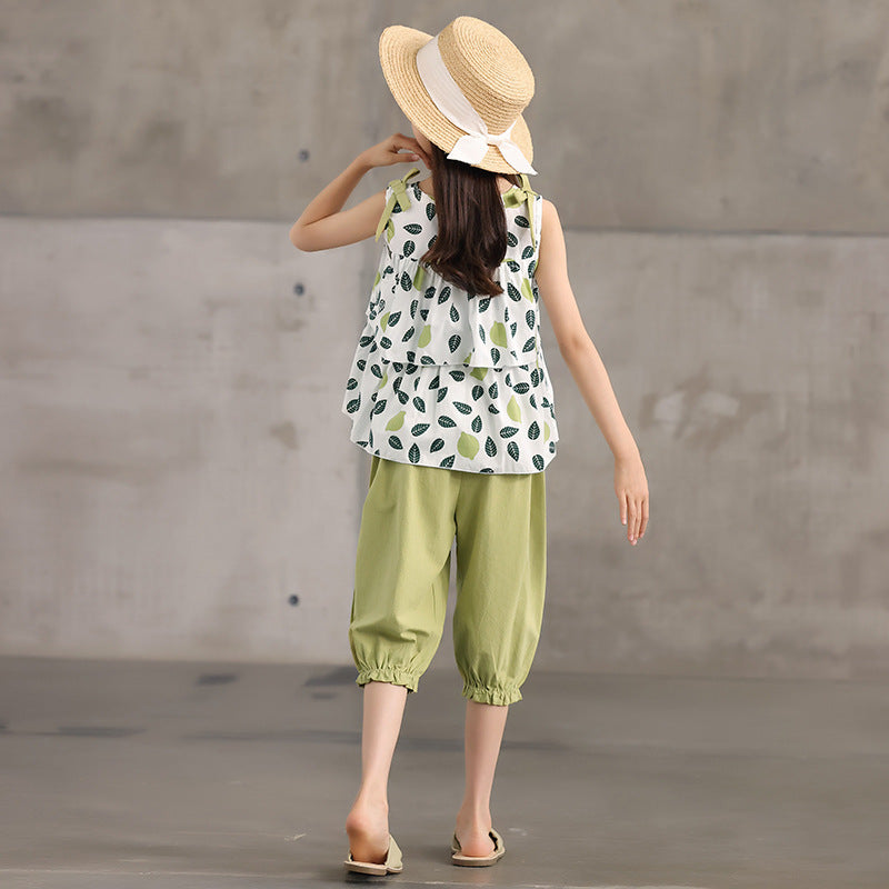 kid in leaf-patterned top and green pants