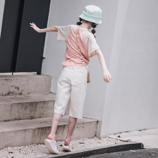 kid girl in beige pant wearing a cap