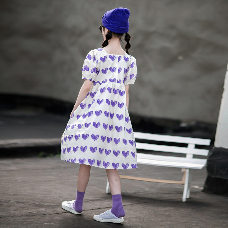 Child in a purple heart-print dress 